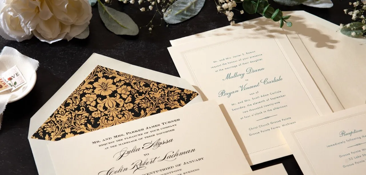 Crane wedding invitations, bordered enclosure cards, cream envelopes, and a black-and-gold floral envelope lining